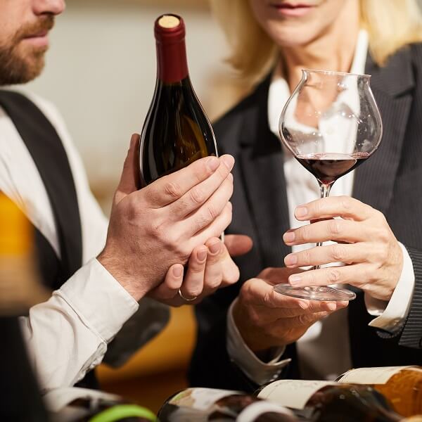 Un homme et une femme tenant des verres de vin, assis à une table, souriant et partageant un moment convivial
